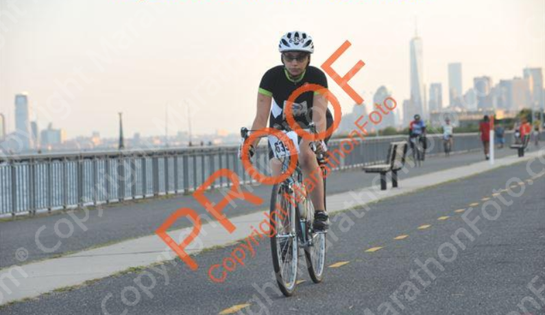 Allie on her bike, riding along the Hudson River on Shore Parkway, with 1WTC in the background
